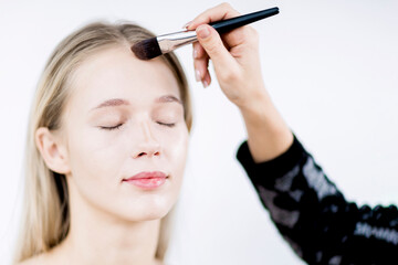 Make-up in the studio. Makeup artist applies tonal foundation.