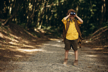 Boyscout travelling in the woods investigating nature