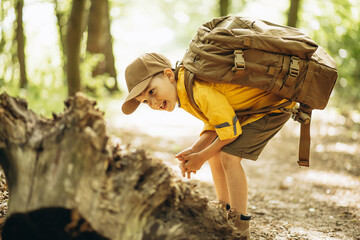 Little boy exploring woods with rucksuck