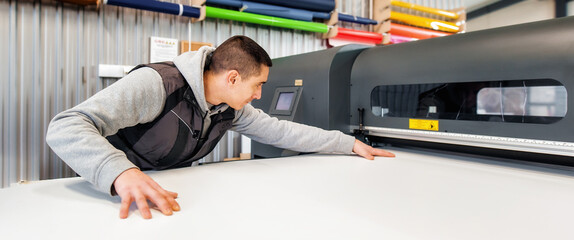 Technician operator works on large premium industrial printer plotter machine - obrazy, fototapety, plakaty