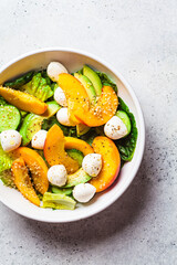 Summer peach salad with avocado, cucumber and mozzarella. Healthy recipe, vegetarian food concept.