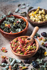 Wooden bowls with medicinal herbs: mint, raspberry, quince, chamomile and rose. Dried herbs of alternative medicine, healthy lifestyle, herbal medicine.