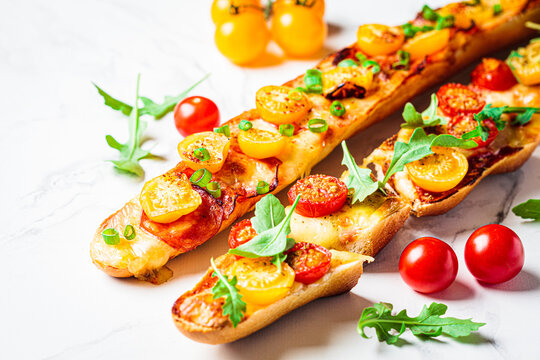 Baguette pizza: vegetarian with cheese and meat with pepperoni. Appetizer idea for party or picnic.