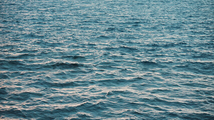 Sun glare on the water. Natural background with sun glints on surface of water. Never endless sea water surface view and sun blaze. Texture of water surface of sea reflection of sun's rays