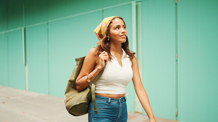 Beautiful girl with tanned skin, brown long hair wearing wireless headphones. Cute young woman with...