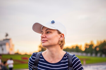 Portrait of a girl in a cap on the background of an open-air urban landscape. Travel. Lifestyle in the city. Center, streets