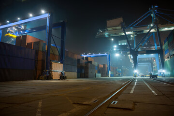 industrial port with containers. Stack of containers, gantry crane at night. Industrial Container...