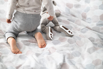 toddler girl little feet with toy rabbit - obrazy, fototapety, plakaty