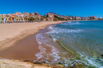 Villajoyosa Spain beautiful sandy beach and clear blue sea with colourful houses and palm trees...