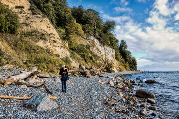 sassnitz, deutschland - frau an der steilküste  der insel rügen mit smartphone