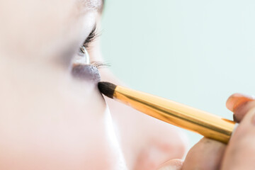 Applying eye shadows to the eyes close up.