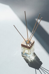 Transparent bottle of aroma diffuser on white background. Eau de parfume for home presentation. Trending concept