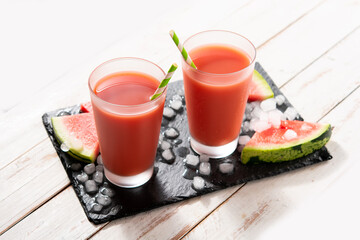 Fresh watermelon juice in glass on white wooden table	