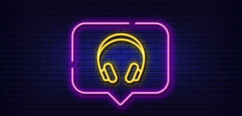 Neon light speech bubble. Headphones line icon. Music listening device sign. DJ or Audio symbol. Neon light background. Headphones glow line. Brick wall banner. Vector