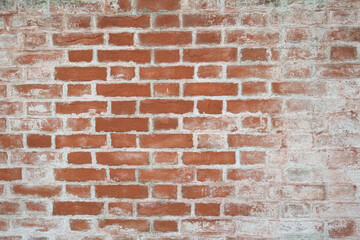 old brick wall covered with remains of lime plaster