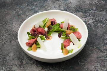 tender salad with roast beef and vegetables on a white plate