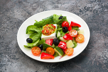 vegetable salad with pickled cheese on a white plate in a restaurant