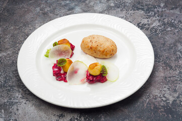fish cutlet with vegetable side dish on a white plate in a restaurant