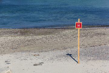 Mines caution sign on the beach