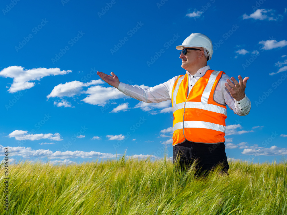 Poster happy engineer-designer. man in builder uniform on field. engineer-designer is satisfied territory f