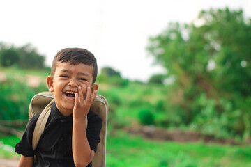 Young smiling happy male kid school boy 5-6 years old in shirt backpack look camera outdoor view,childhood children kids education lifestyle concept.