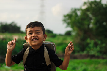 A student boy outside at school standing and smiling,