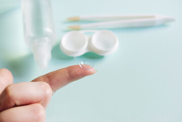 Women's hands with contact lenses and a container for contact lenses.   Medicine and vision concept