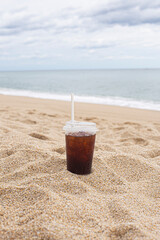 Cold coffee on beach with sea in background