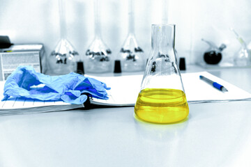 The yellow liquid in the flask is on the table in the laboratory.