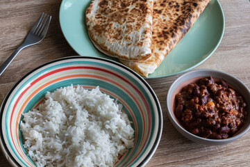 Chili con carne in a bowl accompanied by white rice and quesadillas
