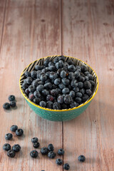 Fototapeta na wymiar Blueberries in a bowl on wooden table