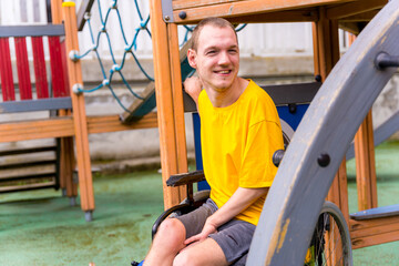 Obraz premium A disabled person in a wheelchair on the swings of a playground