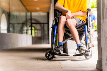 Detail of a disabled person in a wheelchair smiling next to some columns in a doorway