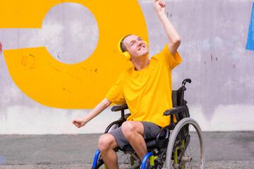 A disabled person in a wheelchair listening to music with headphones, enjoying and dancing