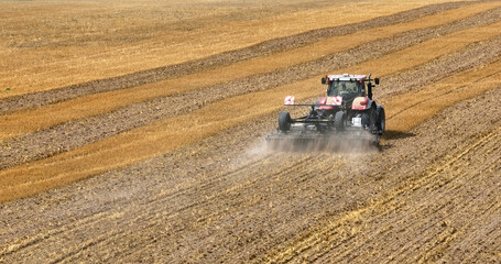 Obraz premium autumn cultivation of the land with red tractor