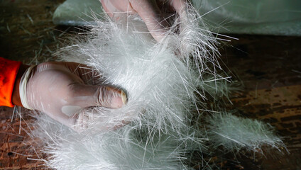 Hand holding composites raw material fiber glass chopper mat stand close up
