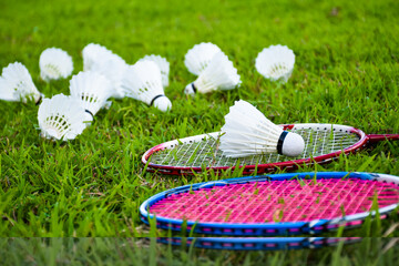 Shuttlecocks and badminton rackets on the green field