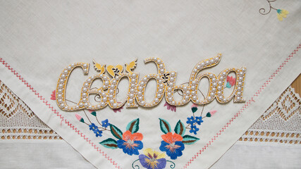 Photo of Handmade word in russian wedding on the background with folk hand embroidery