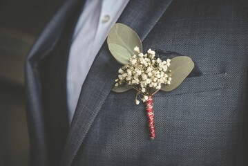 Closeup shot of a boutonniere on the suit of the groom - obrazy, fototapety, plakaty