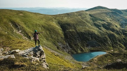 Fototapeta na wymiar Woman tourist on background of green mountains and lake