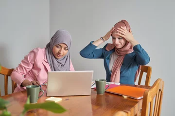 Foto auf Leinwand Two muslim female university students wearing hijab doing schoolwork after class. Morocco college students. © Ladanifer