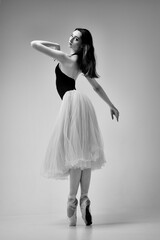a ballerina in a bodysuit and a white skirt improvises classical and modern choreography in a photo...