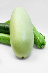 fresh zucchini on a white background. delicious green vegetables on the table. appetizing zucchini on a light texture. healthy food concept
