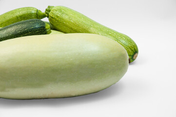 fresh zucchini on a white background. delicious green vegetables on the table. appetizing zucchini on a light texture. healthy food concept