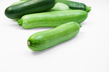 fresh zucchini on a white background. delicious green vegetables on the table. appetizing zucchini on a light texture. healthy food concept