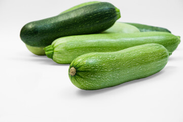 fresh zucchini on a white background. delicious green vegetables on the table. appetizing zucchini on a light texture. healthy food concept