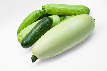 fresh zucchini on a white background. delicious green vegetables on the table. appetizing zucchini on a light texture. healthy food concept