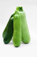fresh zucchini on a white background. delicious green vegetables on the table. appetizing zucchini on a light texture. healthy food concept