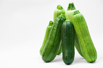 fresh zucchini on a white background. delicious green vegetables on the table. appetizing zucchini on a light texture. healthy food concept