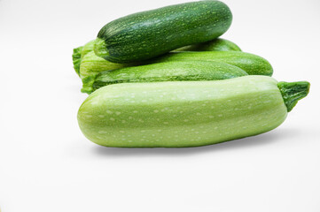 fresh zucchini on a white background. delicious green vegetables on the table. appetizing zucchini on a light texture. healthy food concept